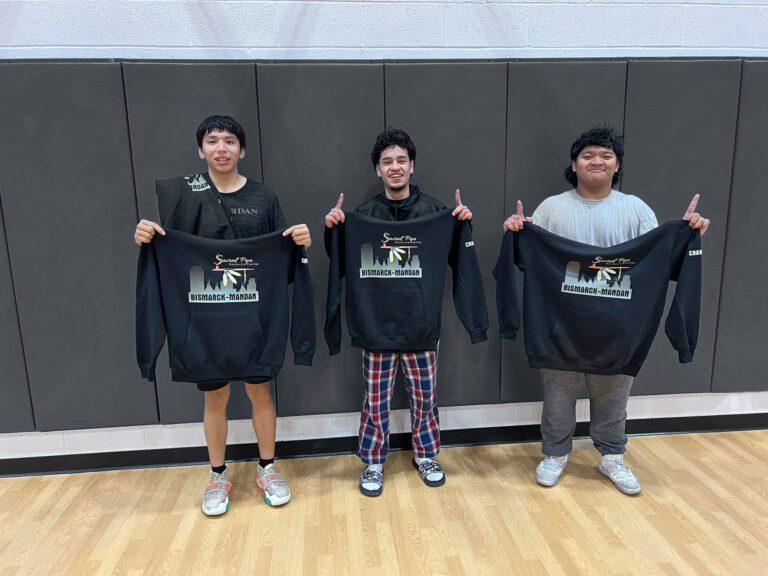 3 boys holding sweatshirts